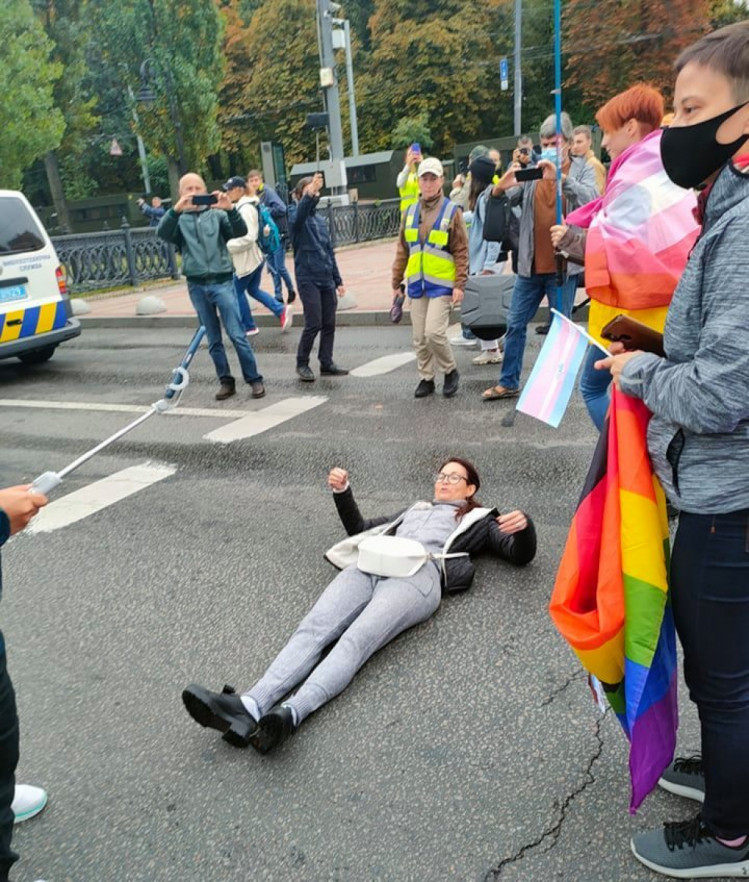 Женщина лежит на тротуаре