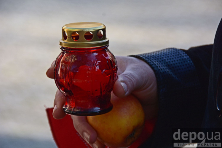 Свічка і яблуко в руках